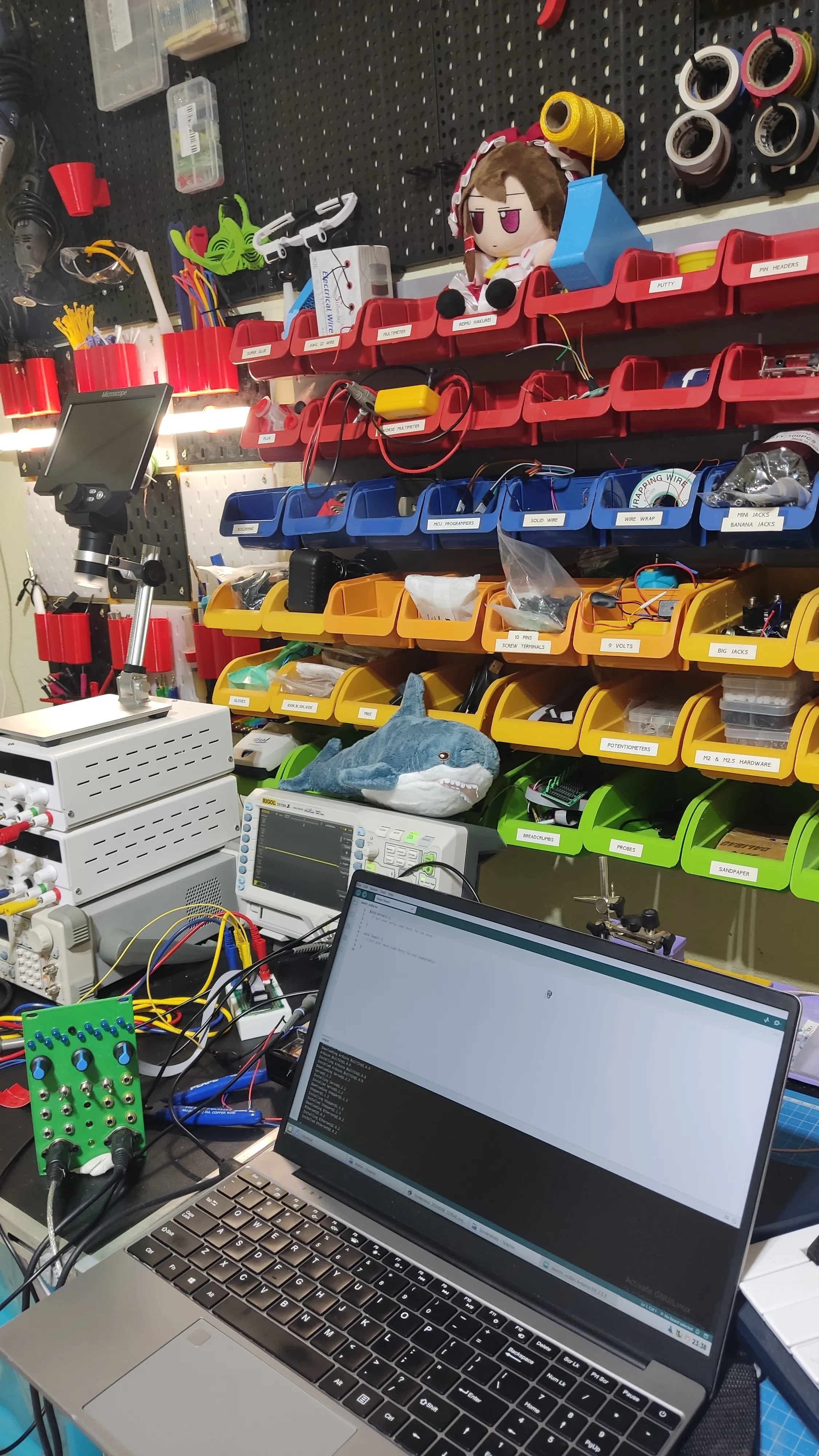 My laptop in my electronics atelier, with a buncha colorful trinkets and plushies. I'm working on diy synths here.