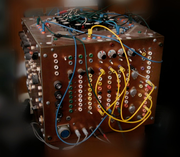 A cube about 30cm wide covered in knobs and banana plugs on all visible sides, with a bunch of cables everywhere