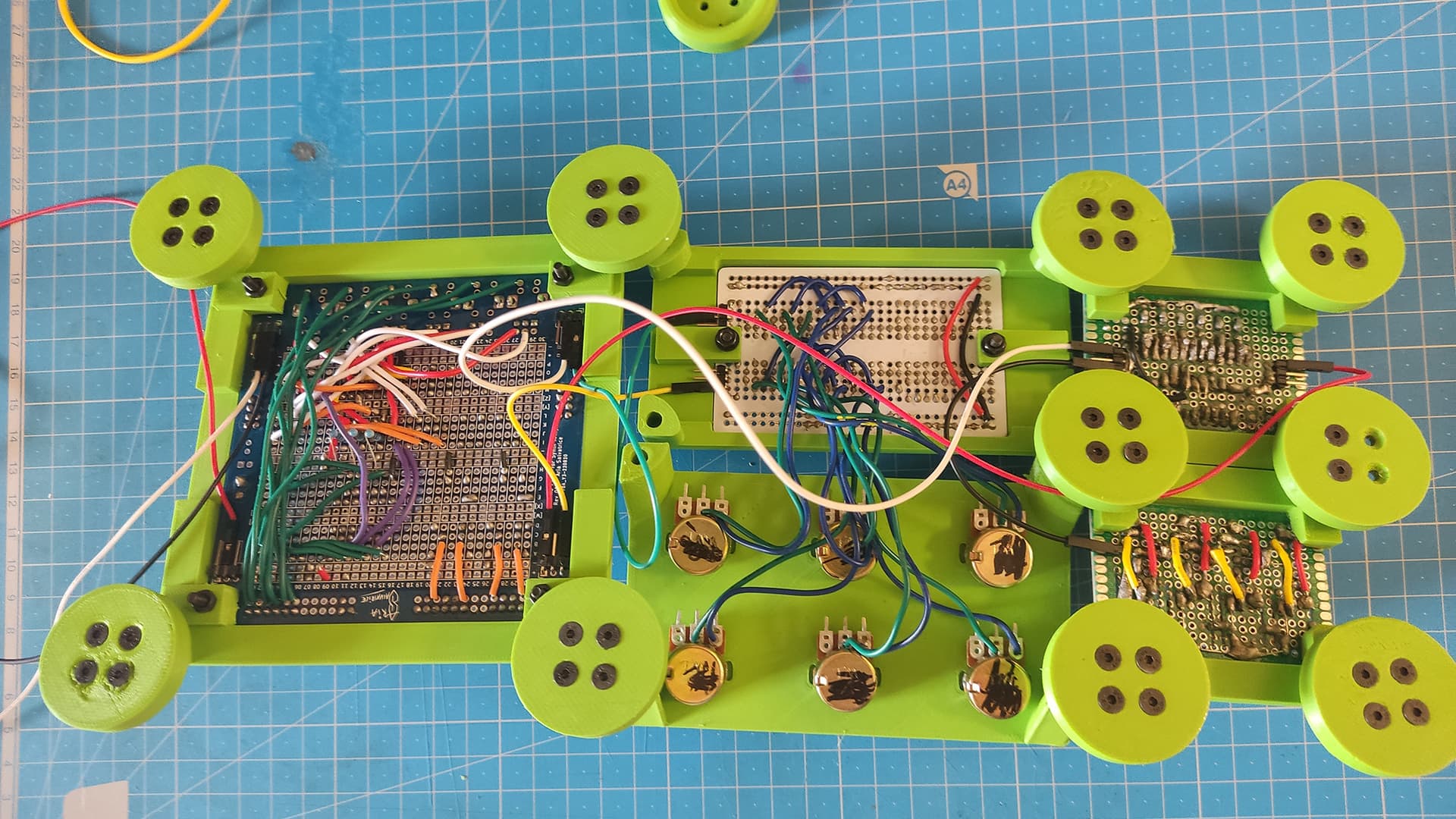 The system flipped upside-down, showing the wires soldered underneath the prototype boards